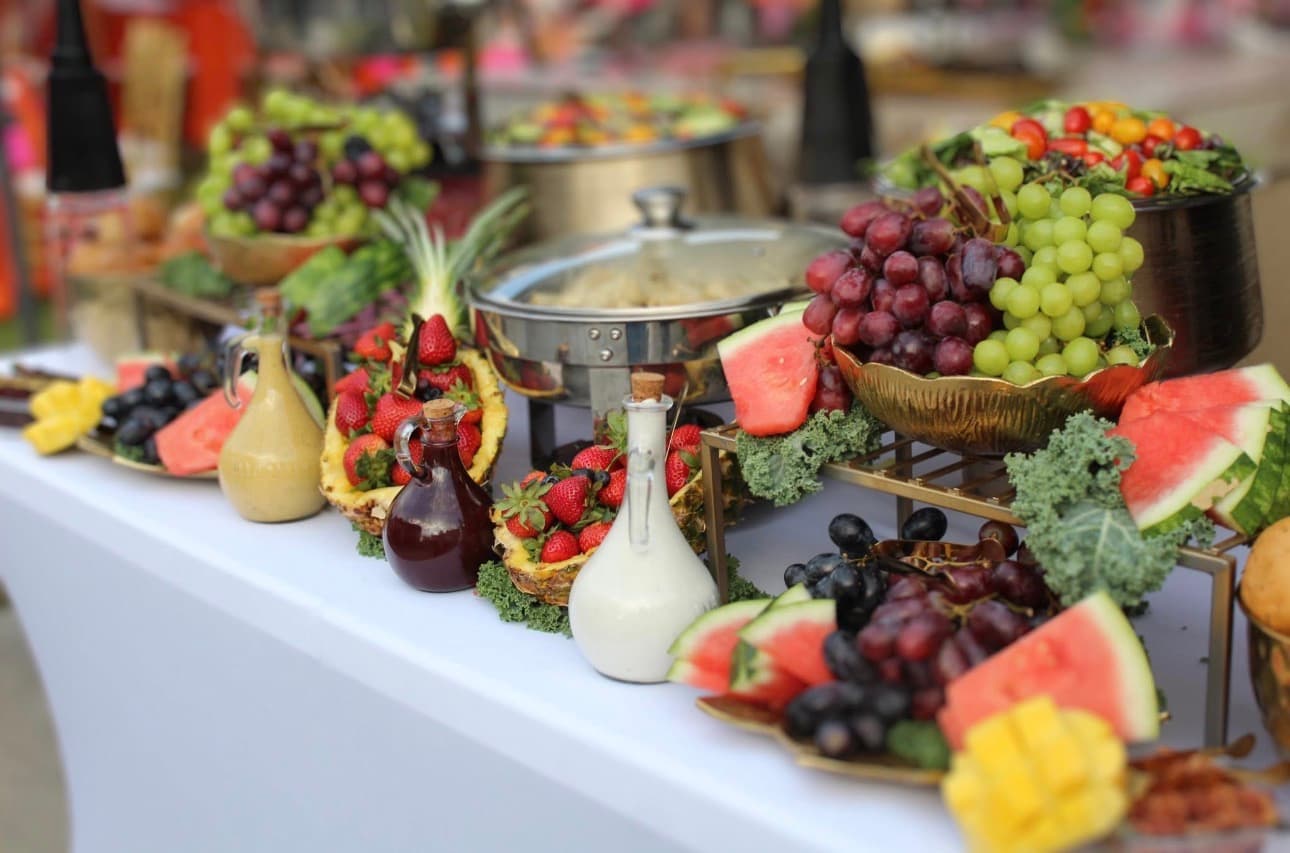 Elegant catered event table setup with fresh fruits and buffet display