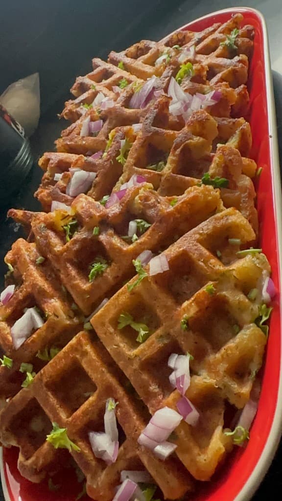 Savory waffles topped with fresh herbs and red onion